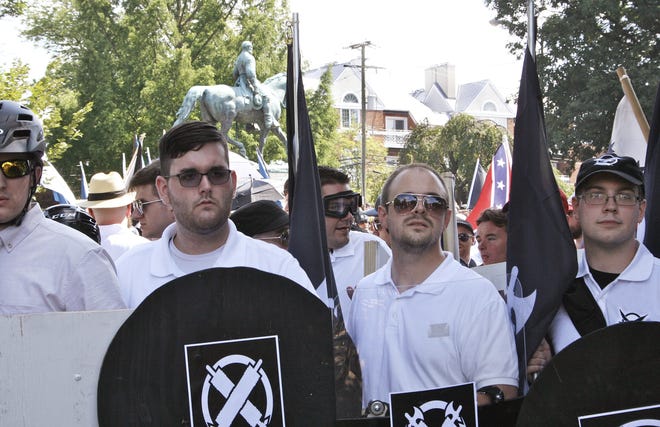 James Alex Fields Jr., second from left, holds a black shield in Charlottesville, Va., where a white supremacist rally took place on Saturday. Fields was later charged with second-degree murder and other counts after authorities say he plowed a car into a crowd of people protesting the white nationalist rally. (Alan Goffinski via AP)