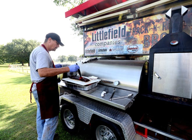 Terry Flanagan adds the glaze to finish off a rack of barbecue ribs from the Littlefield Rack-N-Roll BBQ smoker Saturday, Aug. 12, 2017, for the golfers at the annual Deer Trails Open 4-Person Scramble at the Chaffee Crossing Course. The annual golf tournament included closest to the pin and longest drive competition and flighted awards. [JAMIE MITCHELL/TIMES RECORD]