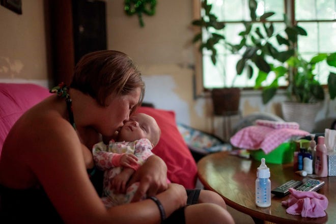 Jennifer Kostoff kisses her 4-month-old daughter, Rikki, at her Granite City, Ill., home.