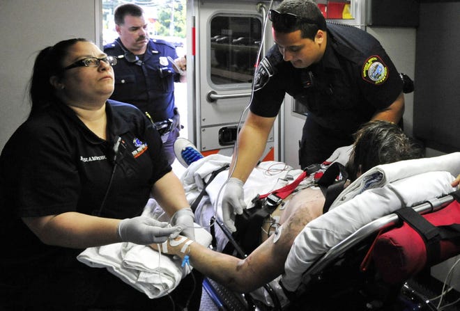 EMTs Megan Robitaille and Shain Ramos tend to a patient following a drug overdose call in New Bedford. [DAVID W. OLIVEIRA/STANDARD-TIMES SPECIAL/SCMG]