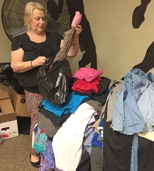 Sandra Cansler helps sort clothes ahead of the First in Families Annual Back to School Clothes Giveaway on Saturday. [Casey White/The Star]