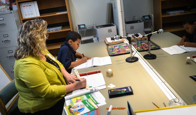 Tuttle Elementary School teacher Laurel Hinds works with first-grader Sean Ivery on his reading and writing skills in front of a one-way mirror (which allows others to observe without being intrusive) during a demonstration in March 2016 of the Reading Recovery program. [HERALD-TRIBUNE ARCHIVE / DAN WAGNER / 2016]