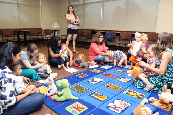 Tiffany Nelson, Miller Branch Library manager, right, leads a group of mothers and their children in a song Monday, Aug. 14, 2017, during Laptime Storytime at the library branch, 8701 S. 28th St. The branch hosts Laptime Storytime for infants 0-24 months on Mondays at 10:30 a.m. and a storytime for older children Fridays at 10 a.m. [JAMIE MITCHELL/TIMES RECORD]