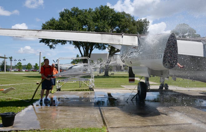 Water is sprayed on an aircraft by a chief petty officer selectee Aug. 10 at Heritage Park.