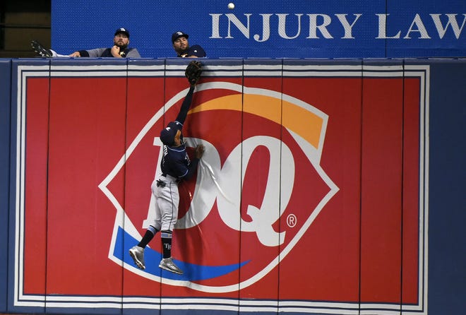 Tampa Bay Rays right fielder Mallex Smith leaps but can't catch a solo home run off the the bat of Toronto's Steve Pearce during the fourth inning on Wednesday in Toronto. [NATHAN DENETTE/THE ASSOCIATED PRESS]