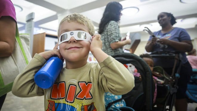 Jonathan Galassini, 4, of West Palm Beach, Fla., tries on a pair of solar eclipse glasses last week. Monday, there will be eclipse-watching events all over Central Texas. Bruce R. Bennett / The Palm Beach Post