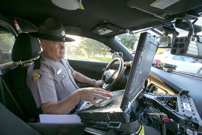 Trooper Jeff Hilliard, of the Florida Highway Patrol, writes a warning for a speeder in the school zone near Greenway Elementary on Midway Road in Ocala on Aug. 19, 2014. [ALAN YOUNGBLOOD / GATEHOUSE MEDIA FILE]