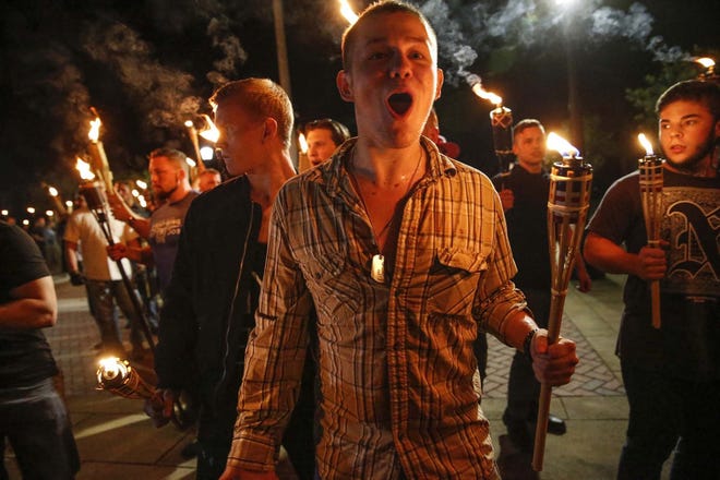 Multiple white nationalist groups march through the University of Virginia campus in Charlottesville, Virginia, on Friday night. [MYKAL MCELDOWNEY/THE ASSOCIATED PRESS]