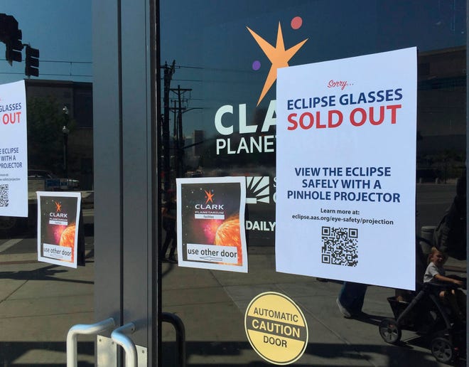 An eclipse glasses sold out sign is posted outside the Clark Planetarium main doors advising people to safely view the eclipse with a pinhole projector after the planetarium ran out of glasses Thursday, Aug. 17, 2017, in Salt Lake City. (AP Photo/Brady McCombs)