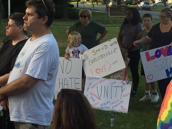 (file) Residents hold signs during vigil Sunday evening at Temple Sinai in Cinnaminson in response to weekend violence in Charlottesville, Virginia.