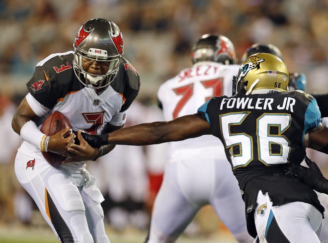 Jacksonville's Dante Fowler Jr., (56) tries to strip the ball from Tampa Bay's Jameis Winston during the first half Thursday in Jacksonville. [Associated Press/Stephen B. Morton]