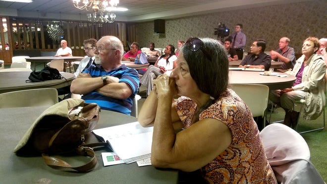 From left, West Third Street residents Frank Sargent and Joan Wasyl listen as Ryan Landi (not pictured) of Cuyahoga Falls, Ohio-based Testa Cos. details plans for the $12 million, 71-unit Bayview Heights housing development Thursday at the MLK Center. [MATTHEW RINK/ERIE TIMES-NEWS]
