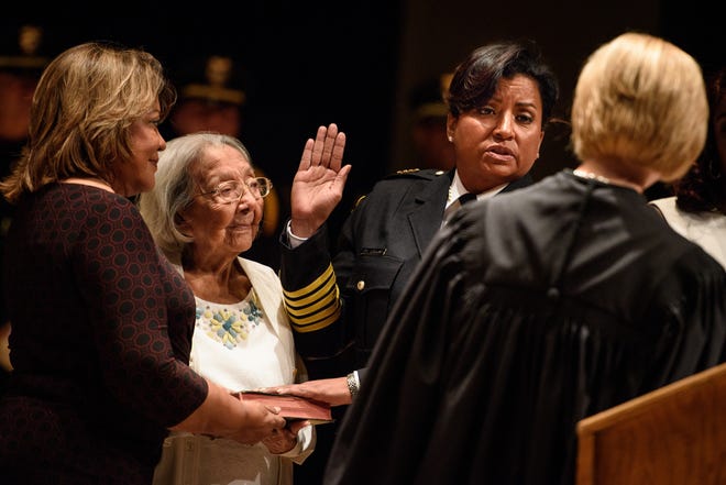 Gina Hawkins is ceremonially sworn in as chief of the Fayetteville Police Department by Superior Court Judge Claire Hill on Friday at Fayetteville State University. Hawkins, officially sworn in earlier this week by Hill, is the first woman to hold the position on a permanent basis. Holding the Bible is Hawkins' mother, Yadira Hawkins, left, and her grandmother, Aurora Esquivel. [Andrew Craft/The Fayetteville Observer]