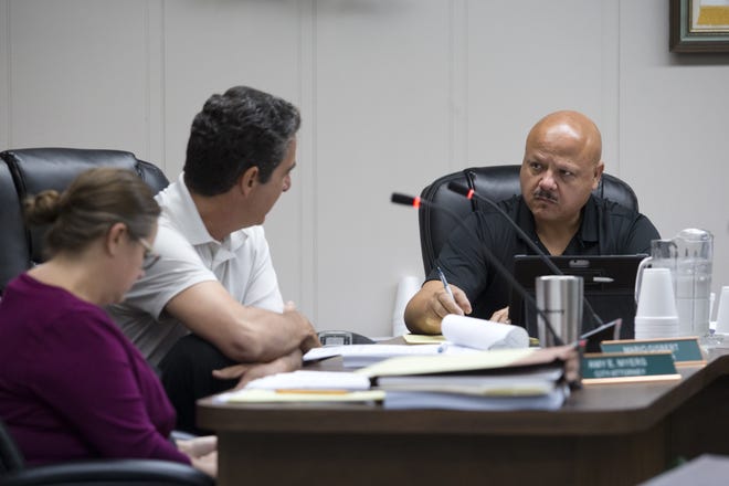 Councilman Hector Solis, right, speaks with City Manager Mario Gisbert during a recent Panama City Beach City Council meeting. At left is city attorney Amy Myers. [JOSHUA BOUCHER/THE NEWS HERALD]