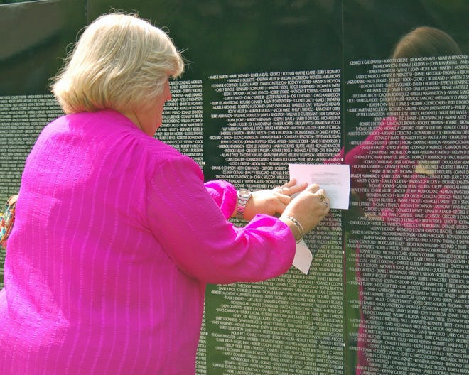 The Moving Wall brought many visitors to the opening. Volunteers have materials available for visitors to make etchings of a loved one's name. 

[Wicked Local Photo/Debra Cordeiro]