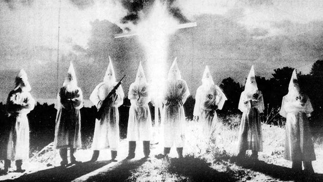 Klan members in front of a burning cross at an October, 1979 rally off Belvedere Road west of West Palm Beach (Palm Beach Post archives)