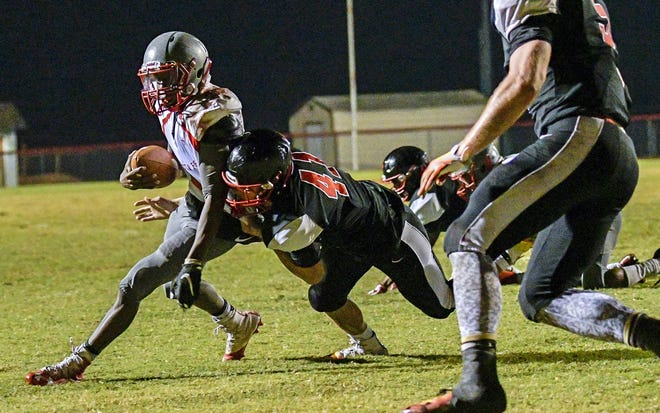 Santa Fe's Julien Cromwell (10) is brought down by South Sumter's Matt Palmer (41) at a Class 4A regional semifinal game between South Sumter High School and Alachua Sante Fe High School in Bushnell on Nov. 11, 2016. [PAUL RYAN / CORRESPONDENT]