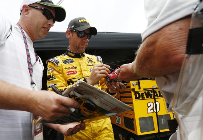 Driver Matt Kenseth signs autographs for fans after practice for the NASCAR Monster Energy Cup Series auto race, Friday, Aug. 18, 2017, in Bristol, Tenn. (AP Photo/Wade Payne)