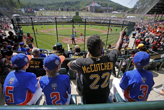 Grosse Pointe, Mich.'s players Matthew Greene (5), Tommy Harris (2), and Branden Campbell (3) sit with Pittsburgh Pirates' Andrew McCutchen (22) in the stands at Lamade Field during a baseball game on Sunday. [GENE J. PUSKAR/AP PHOTO]
