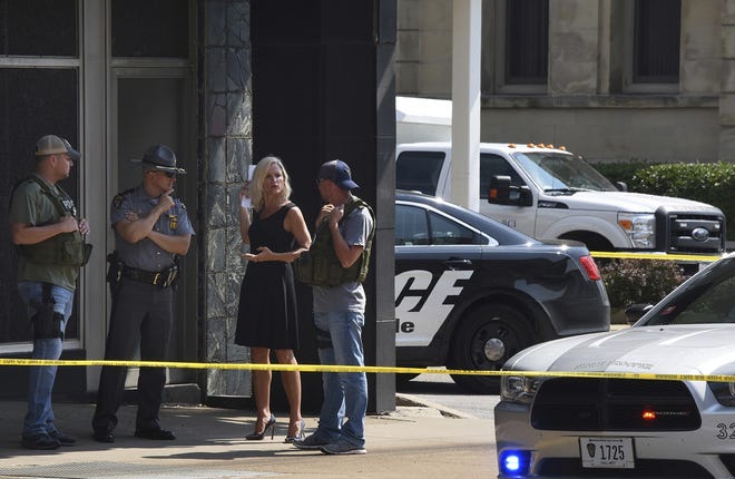 Officials consult near the crime scene at the Huntington Bank, next to the Courthouse in Steubenville, Ohio, Monday Aug. 21, 2017, after Jefferson County Judge Joseph Bruzzese Jr. was ambushed and shot while walking to work early Monday morning. (Darrell Sapp/Pittsburgh Post-Gazette via AP)