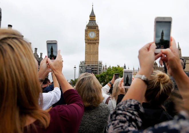 People record the last bell bong at Elizabeth Tower in London, Monday, Aug. 21, 2017. At noon, Big Ben's famous bongs sounded for the last time before major conservation works are carried out. The Elizabeth Tower, home to the Great Clock and Big Ben, is currently undergoing a complex programme of renovation work that will safeguard it for future generations. While this vital work takes place, the Great Bell's world famous striking will be paused until 2021 to ensure the safety of those working in the Tower.(AP Photo/Frank Augstein)
