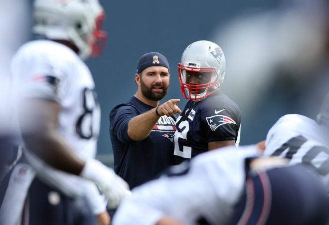 Retired defensive lineman Rob Ninkovich works with Geneo Grissom during practice.
