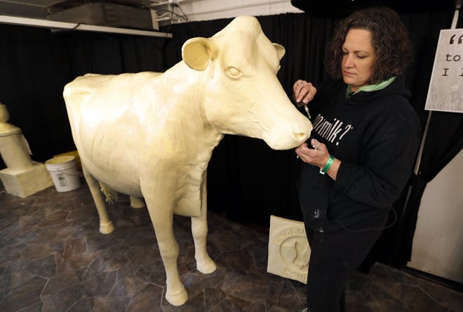 Sculptor Sarah Pratt works on this year's Butter Cow at the Iowa State Fair in Des Moines, Iowa. [AP Photo/Charlie Neibergall]