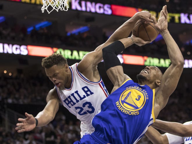 (File) The 76ers' Justin Anderson contests the shot of the Warriors' David West during a February 2017 game at the Wells Fargo Center.