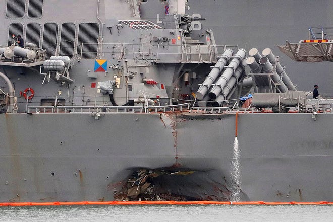 The damaged port aft hull of USS John S. McCain, is seen while docked at Singapore’s Changi naval base on Tuesday, Aug. 22, 2017 in Singapore. The focus of the search for 10 U.S. sailors missing after a collision between the USS John S. McCain and an oil tanker in Southeast Asian waters shifted Tuesday to the damaged destroyer’s flooded compartments. (AP Photo/Wong Maye-E)
