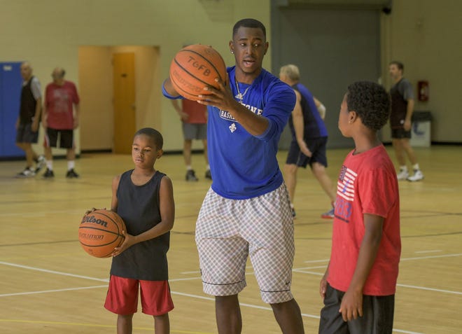 P.J. Foster works with children at the Leesburg Recreation Center in Leesburg earlier this month. Foster, a professional basketball player who grew up in Leesburg, works part time for the Recreation Department. PAUL RYAN / CORRESPONDENT]