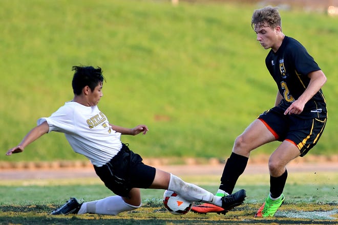Shelby's Felix Costilla goes in for a slide tackle against Kings Mountain's Chase Yow during their match at Shelby High School on Wednesday. [Brittany Randolph/The Star]