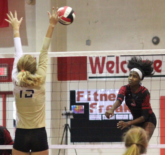 Jacksonville's Jayda Hunter fires the ball past an attempted block by Croatan's Ki-Kil Klaumann during the Cardinals' five-set nonconference victory Thursday night at The Bird Cage. [Rick Scoppe/The Daily News]