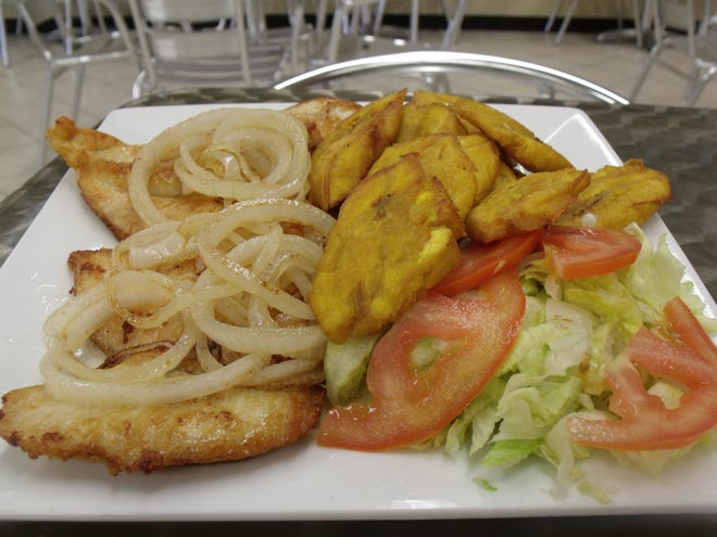 The grilled chicken breast is a popular choice at Latin Cuisine Restaurant. It comes with two grilled chicken breasts topped with grilled onions and served with fried plantains, lettuce and tomato. [Alison Minard for The Fayetteville Observer]