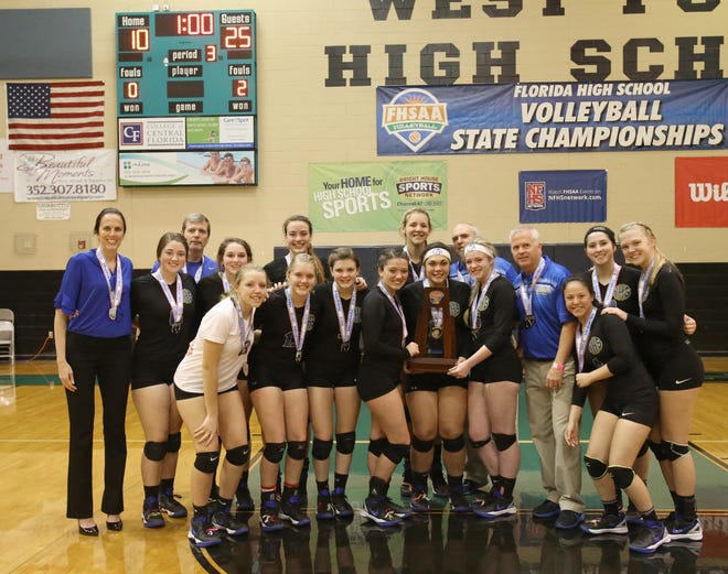 Newberry players and coaches pose with the FHSAA volleyball Class 1A runner-up trophy after losing to Sneads in the title match at West Port High School in Ocala last November. [Bruce Ackerman/GateHouse Media Services/File]