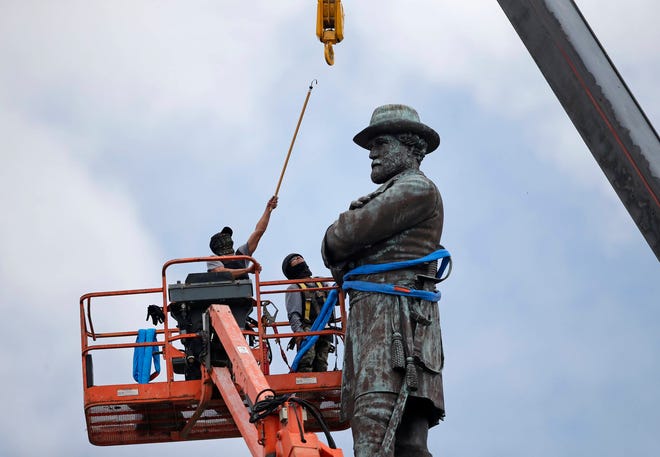 In this Friday, May 19, 2017, file photo, workers prepare to take down the statue of former Confederate Gen. Robert E. Lee, which stands over 100 feet tall, in Lee Circle in New Orleans. (AP Photo/Gerald Herbert, File)