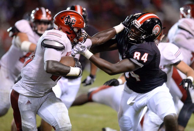 New Castle's Marcus Hooker stiff arms Aliquippa's Zuriah Fisher (84) on Friday at Aliquippa High School.