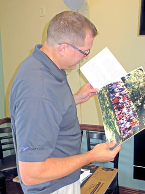 Fredericksburg Presbyterian Church pastor Jack McClelland peruses an old congregation photograph while digging through boxes of historical material resurrected for the church's upcoming bicentennial celebration.