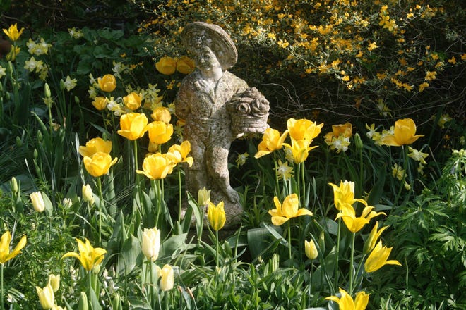 This April 19, 2009 photo taken in a private garden in rural Belgium demonstrates how eye-catching statuary can be used to personalize flower gardens. Garden antiques can be made of wicker, metal or stone and range from pergolas to fountains, outdoor furniture to gates. Adding antique collectibles to the landscape blends gardening with history. It can be richly rewarding. (Dean Fosdick via AP)