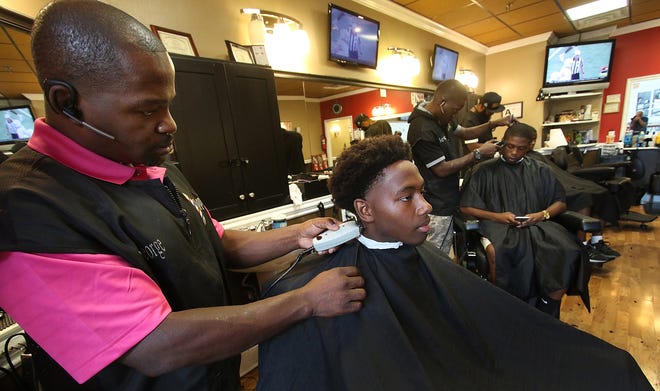 Ashbrook High School senior D'Andre Britt has his hair cut by barber George Crosby at The ShoppE barber shop in the Eastridge Mall on Saturday afternoon, Aug. 26, 2017. [Mike Hensdill/The Gaston Gazette]