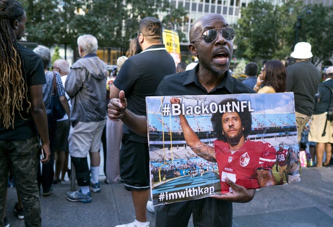 Eric Hamilton of New York joins others gathered in support of unsigned NFL quarterback Colin Kaepernick on Wednesday, in front of NFL headquarters in New York. [CRAIG RUTTLE/AP]