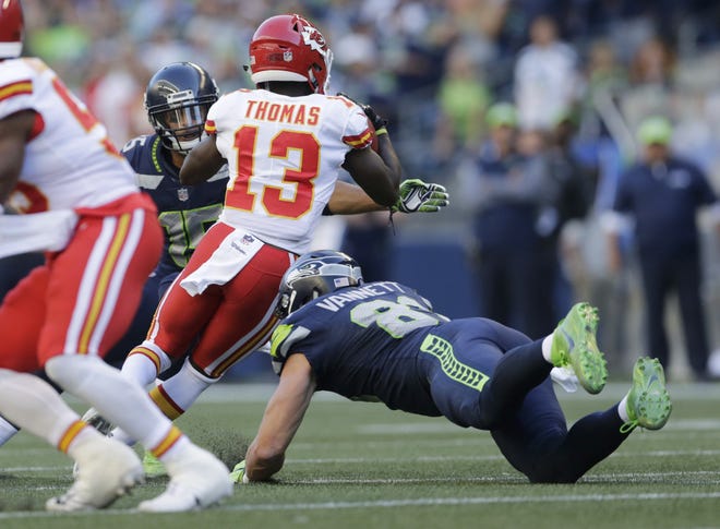 Chiefs kick returner De'Anthony Thomas (13) dodges a pair of Seahawks as he weaves his way 95 yards for a second-quarter touchdown. [ASSOCIATED PRESS]