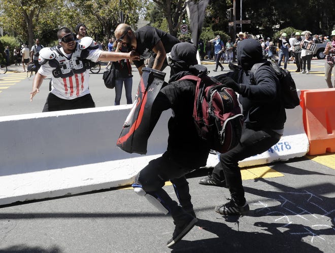Demonstrator Joey Gibson, second from left, is chased by anti-fascists during a free speech rally Sunday, Aug. 27, 2017, in Berkeley, Calif. Several thousand people converged in Berkeley Sunday for a "Rally Against Hate" in response to a planned right-wing protest that raised concerns of violence and triggered a massive police presence. Several people were arrested for violating rules against covering their faces or carrying items banned by authorities. (AP Photo/Marcio Jose Sanchez)