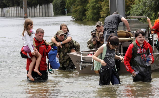 Residents are rescued from their homes surrounded by floodwaters from Tropical Storm Harvey on Sunday, Aug. 27, 2017, in Houston, Texas. (David J. Phillip/The Associated Press)