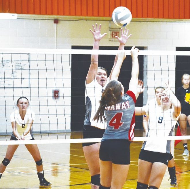 Onaway's Calley Selke (4) delivers a hit while Cheboygan's Angie Swiderek (middle) and Jackie Swiderek (9) go to block the kill attempt during the first set of a non-conference matchup in Cheboygan on Monday.
