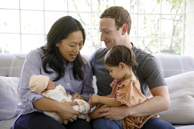 This photo provided Monday, Aug. 28, 2017, by Facebook, shows Facebook CEO Mark Zuckerberg with his wife, Priscilla Chan, and their new baby daughter August, left, and her sister Maxima, right, in Palo Alto, Calif. On Monday, Zuckerberg announced August's birth on his Facebook page. (Charles Ommanney/Facebook via AP)