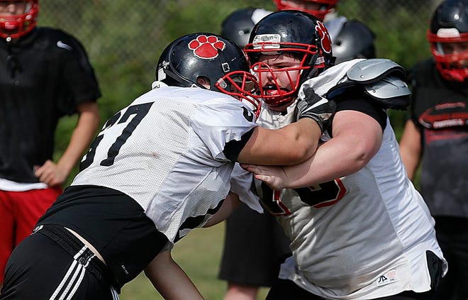 Whitman-Hanson's Riley Holland, left, works on a blocking drill during practice on Wednesday, August 23, 2017.