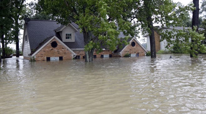 A home is surrounded by floodwaters from Tropical Storm Harvey on Monday in Spring, Texas. [AP Photo/David J. Phillip]