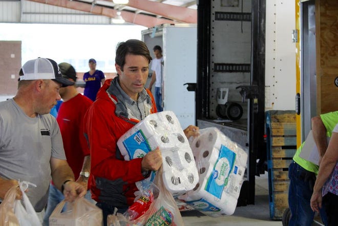 U.S. Congressman Garret Graves loads a heap of toilet paper onto a trailer bound for Texas.