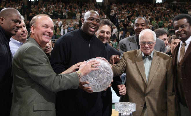 FILE - In this Feb. 22, 2009, file photo, members of Michigan State's 1979 NCAA championship basketball team, including front row from left, Jay Vincent, Terry Donnelly, Earvin "Magic" Johnson, coach Jud Heathcote and Gerald Gilkie, hold the championship trophy during a ceremony commemorating the 30th anniversary of the event during halftime of an NCAA college basketball game between Michigan State and Wisconsin in East Lansing, Mich. Heathcote, who led Michigan State and Magic Johnson to the 1979 NCAA championship, has died. He was 90. The school says Heathcote died Monday, Aug. 28, 2017, in Spokane, Washington. (AP Photo/Al Goldis, File)