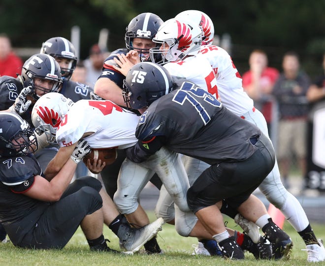 Marcus Cain (No. 74) and Stephen Baxter (No. 75), combining to make a tackle in a Week 1 win over Sandy Valley, are two leaders of the Fairless defensive line. (FridayNightOhio.com / Kevin Whitlock)